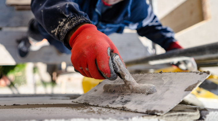 Image showing a professional smoothing freshly poured concrete on a driveway with precision tools.